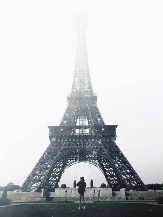 people are walking by the eiffel tower in the winter