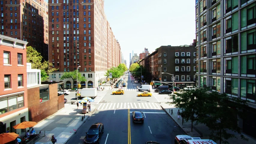 an aerial view of a downtown street with cars and pedestrians