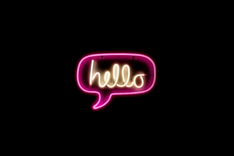 a neon sign that says hello hanging from the side of a building