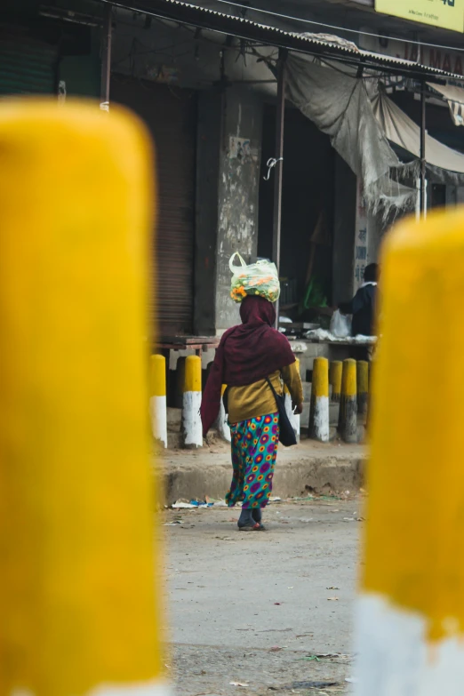 a person walking on a road with yellow posts