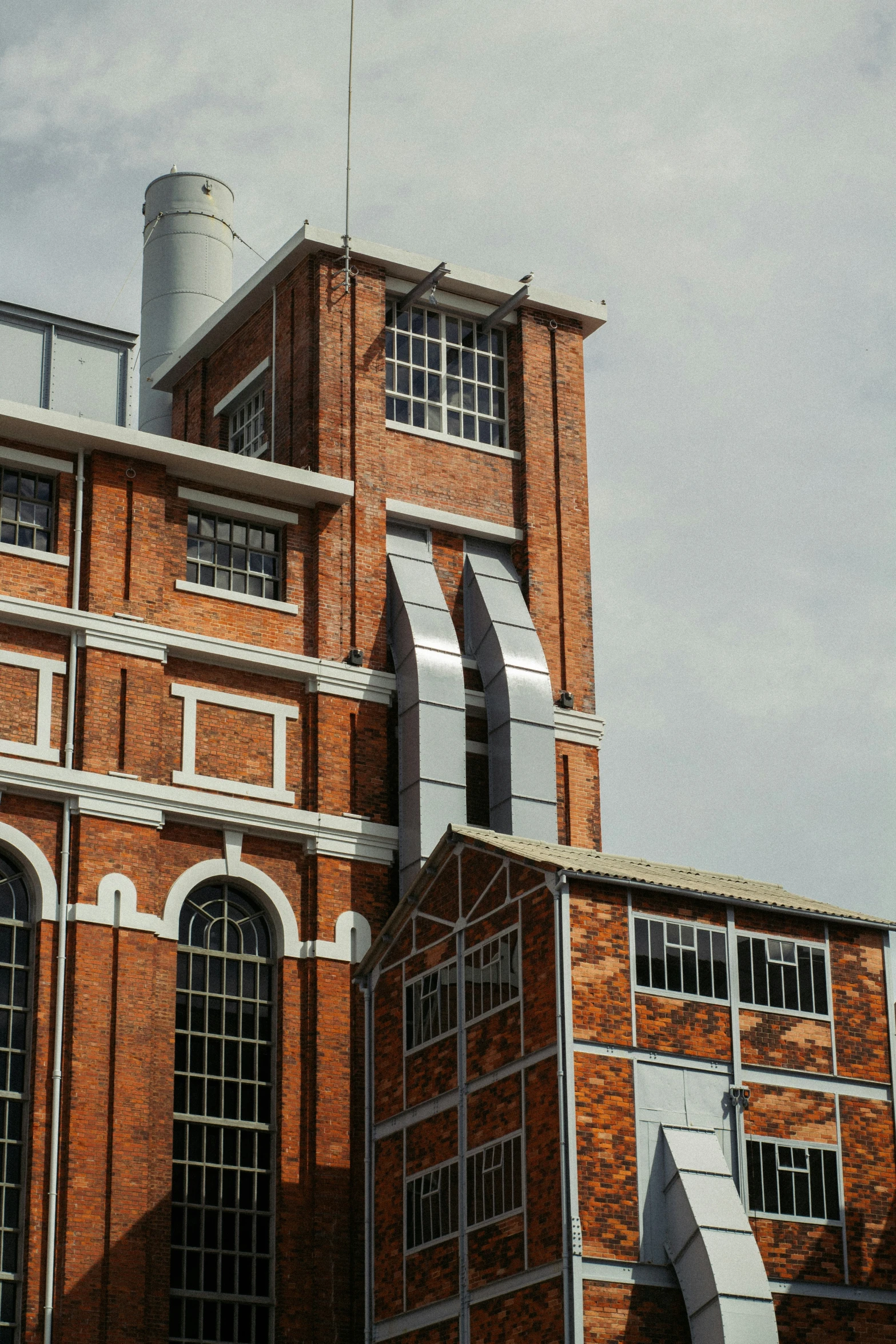 a brick building with an iron gate and a clock on the top