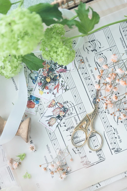 a floral arrangement and a pair of glasses sitting on a music sheet