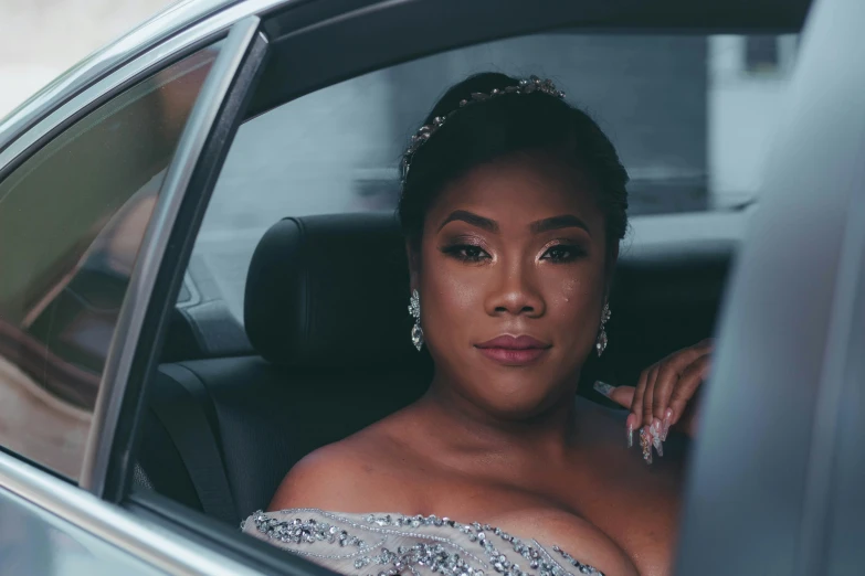 a young woman sits in the passenger seat of a car