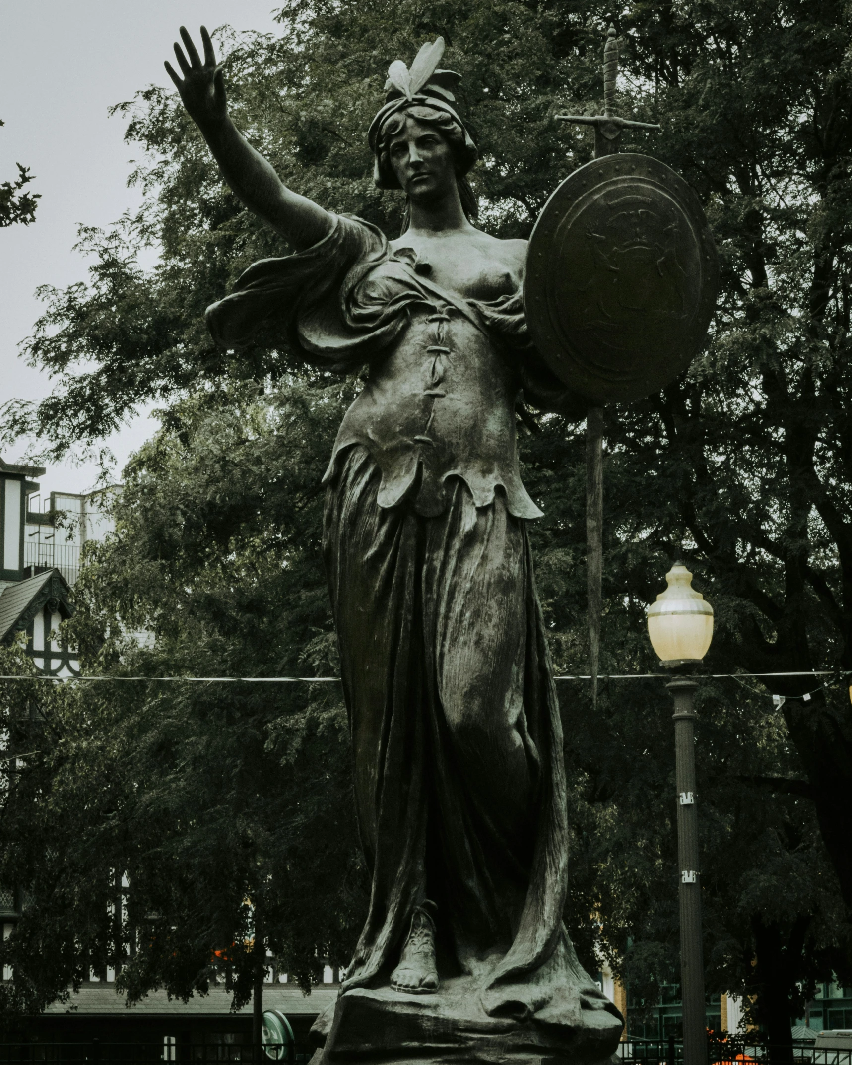 the statue of lady justice stands in a park