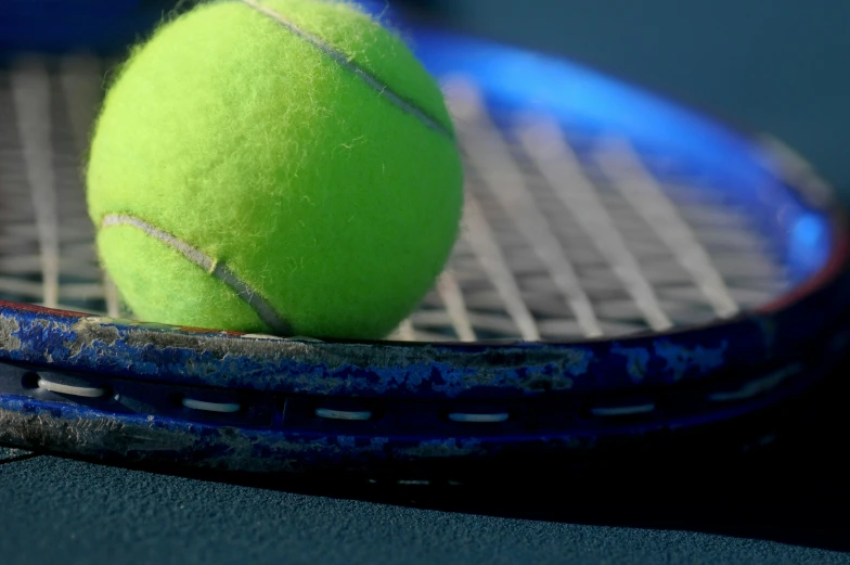 two tennis balls sitting next to each other on a racket