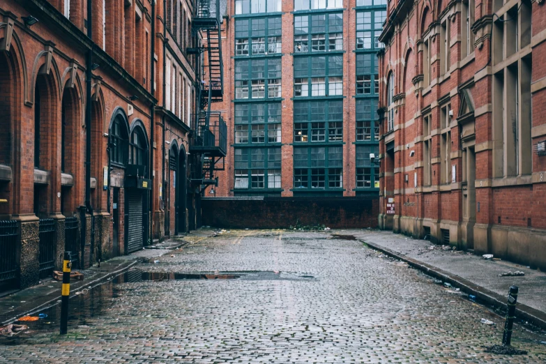 an empty walkway between two red brick buildings