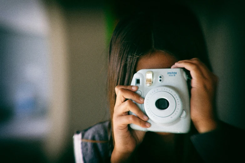 a woman taking a po of herself with a white camera