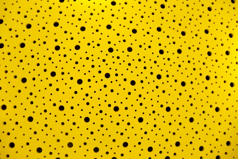 a very large yellow wall with many black dots on it