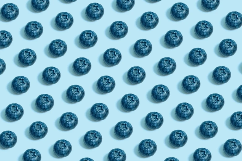 a blue wall that has blueberry halves arranged in an array