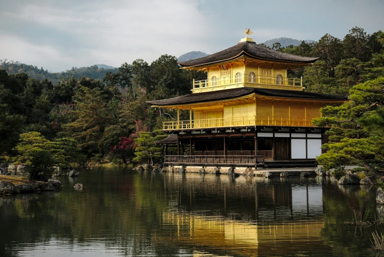 a yellow pavilion sitting in the middle of a lake