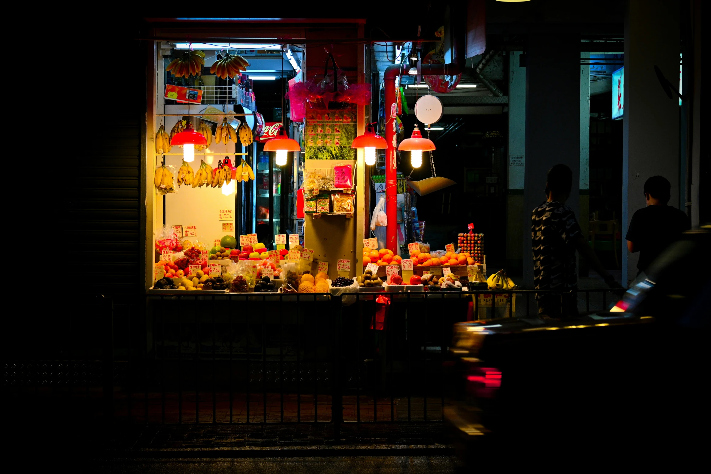 a street with traffic at night and people outside