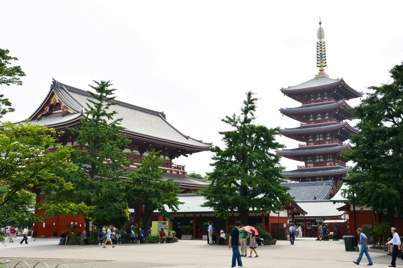 several people standing in front of the three - story pagoda