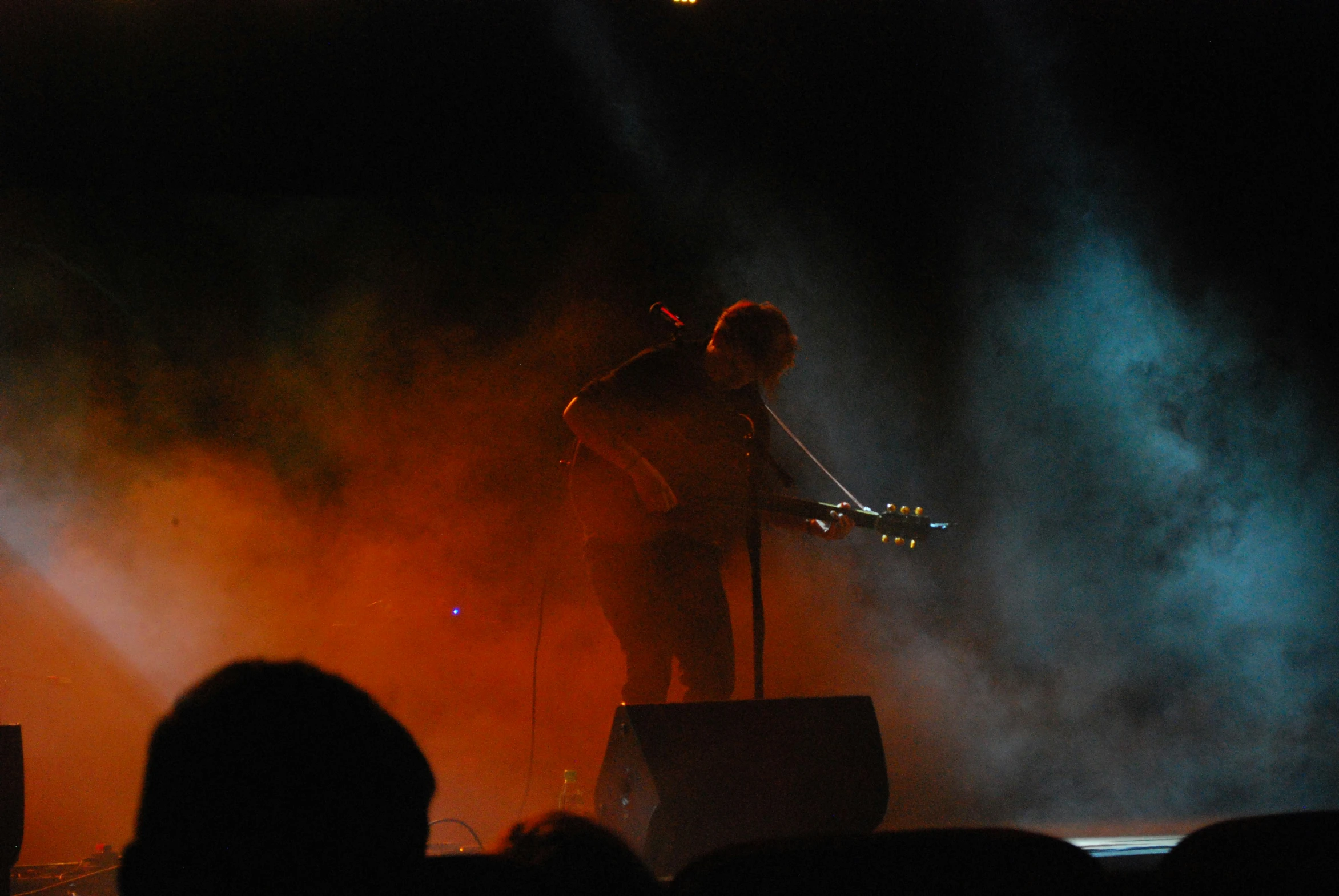 the man is standing on stage with his guitar in hand