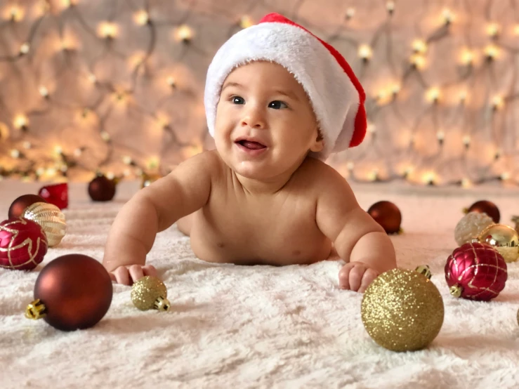 a baby wearing a santa hat and some christmas decorations