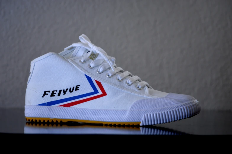 a white tennis shoe with a logo on it