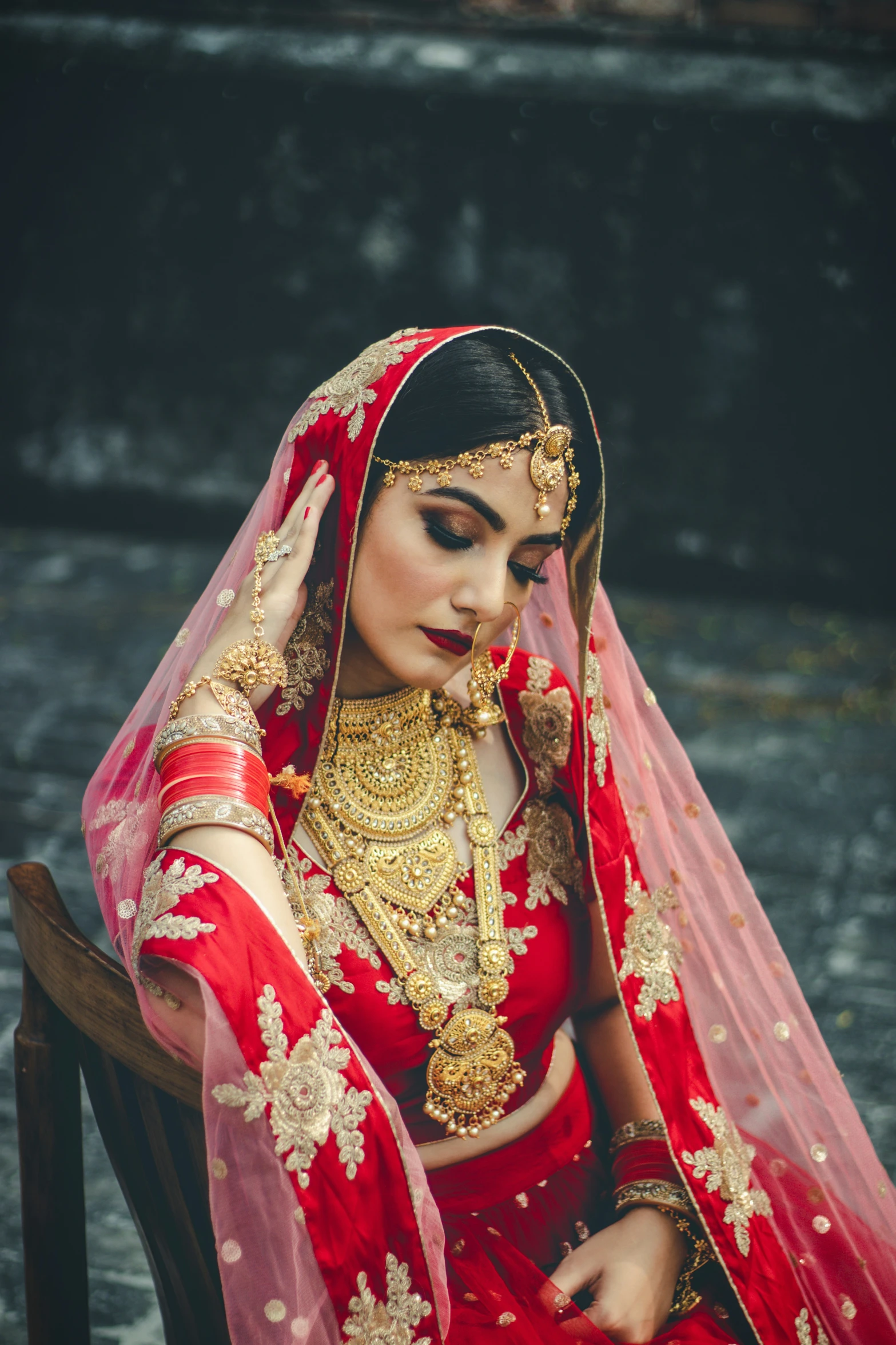 a young woman dressed in a wedding attire sitting down