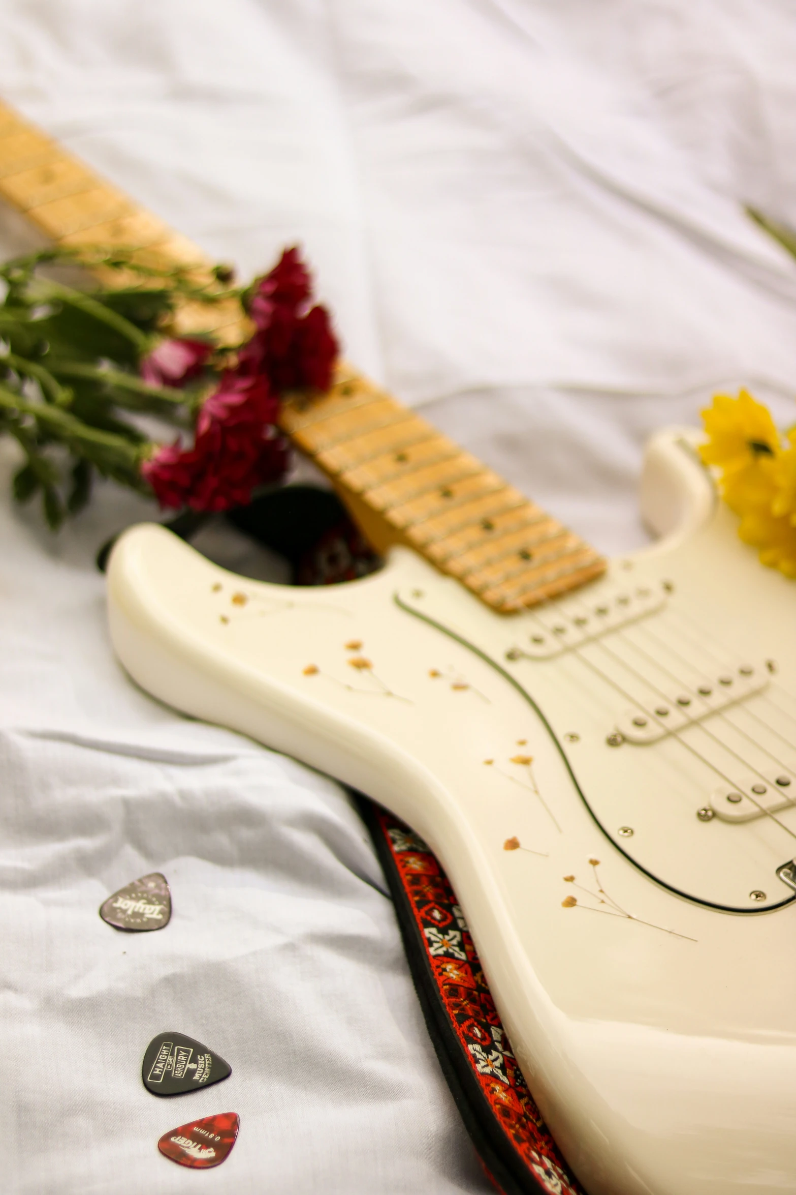 there is a flower on the table next to a guitar