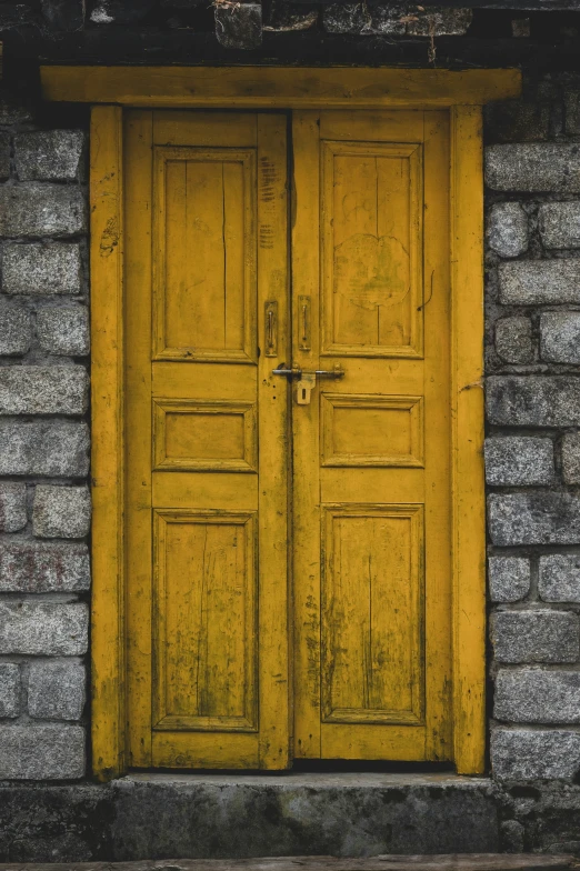 a picture of a yellow door in front of a brick wall