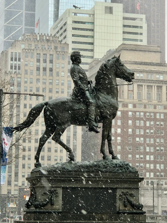 a statue of a person riding a horse in the snow