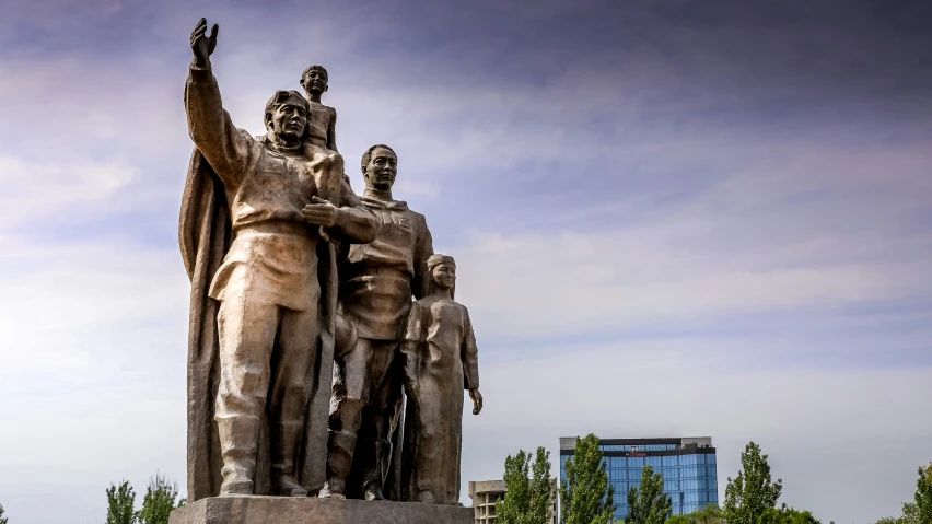 a group of three people standing next to a statue