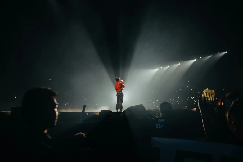 a person stands on stage on a cold night