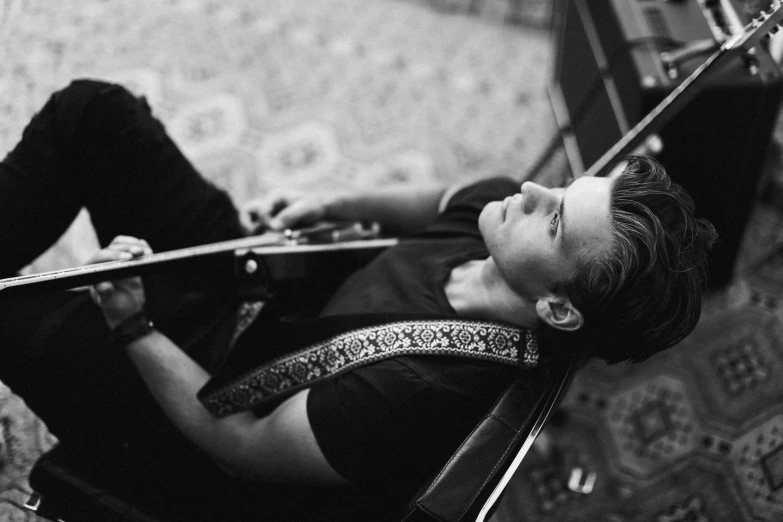 a woman playing the violin while laying on the ground