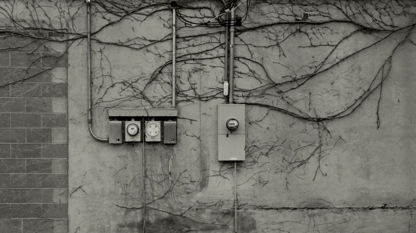 some electrical boxes and wires are on a wall