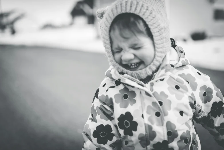 little child laughing with snow in background