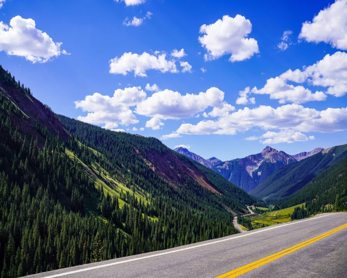 an empty road with mountains in the background