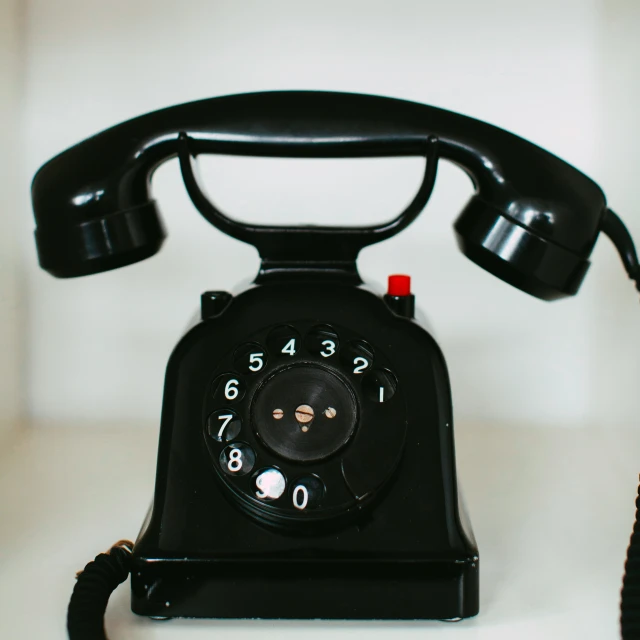 a rotary type telephone on a white surface