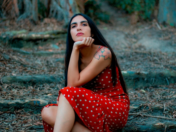 a woman sitting on the ground with her hands clasped