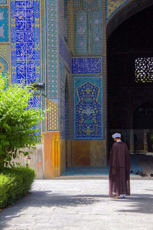 a man is standing on the pathway outside of a building