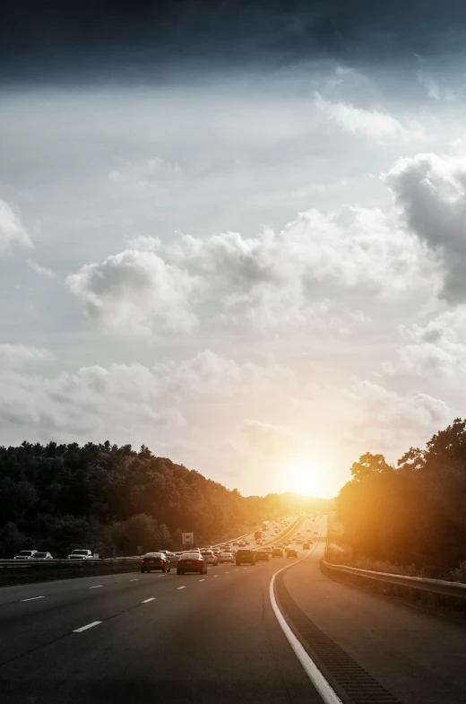the sun rises above cars on a highway