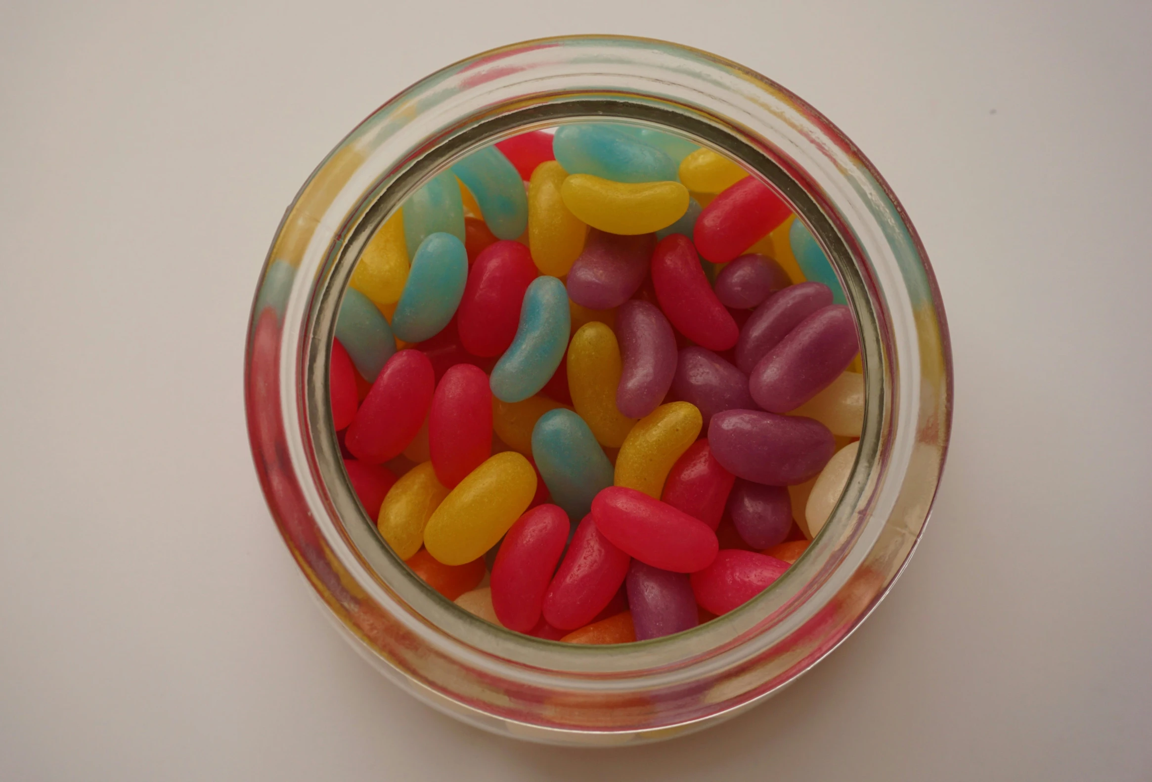 a glass bowl filled with candy on top of a white counter