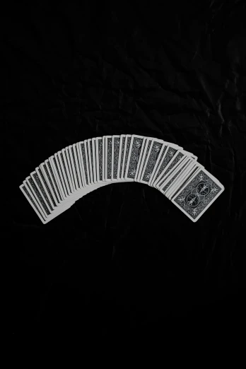 a collection of white playing cards lying on a black background