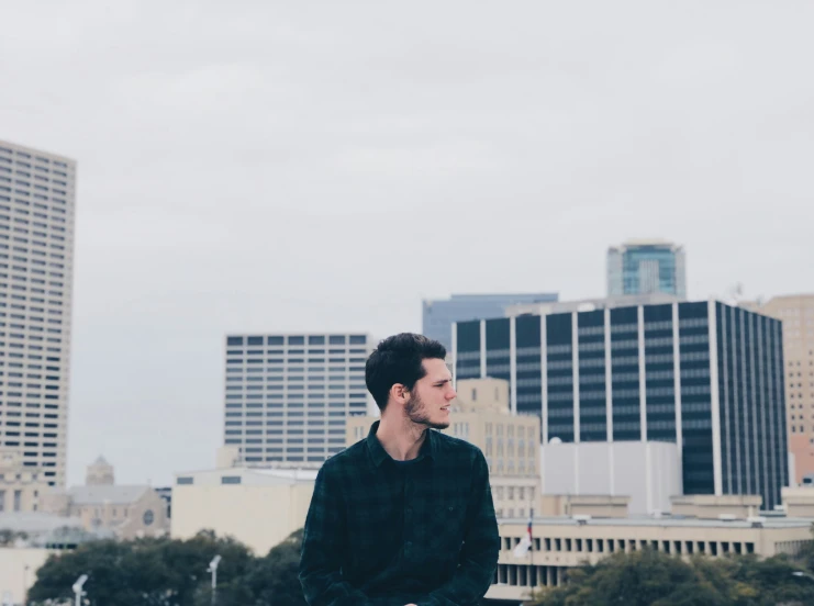 a man standing in the middle of a field looking away from the camera