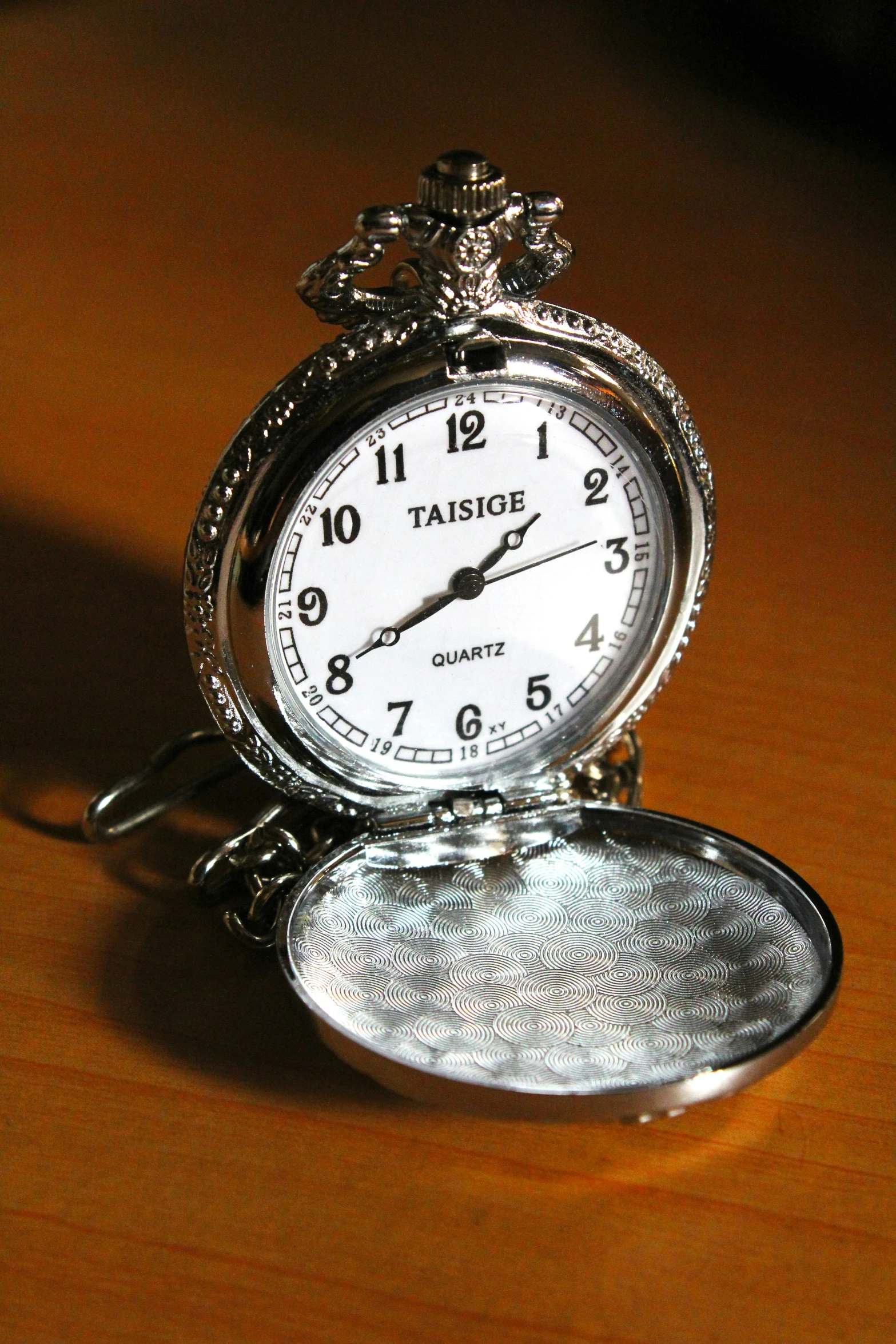 a watch on a brown table top