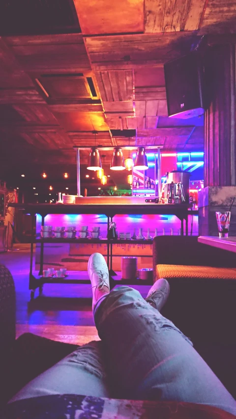 a person in a bar with legs and legs crossed