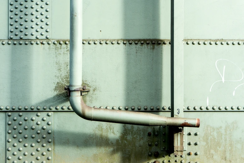 pipe on the wall with graffiti in white