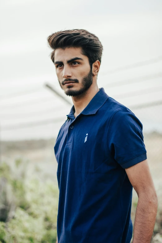 a bearded man in polo shirt looking at the camera