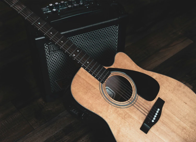 a wooden acoustic guitar on display next to amp