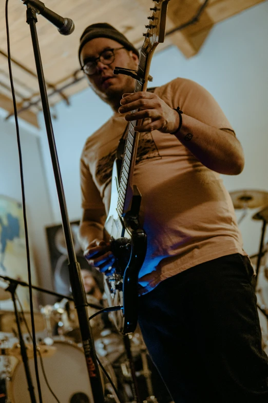 a woman playing guitar while standing next to a microphone