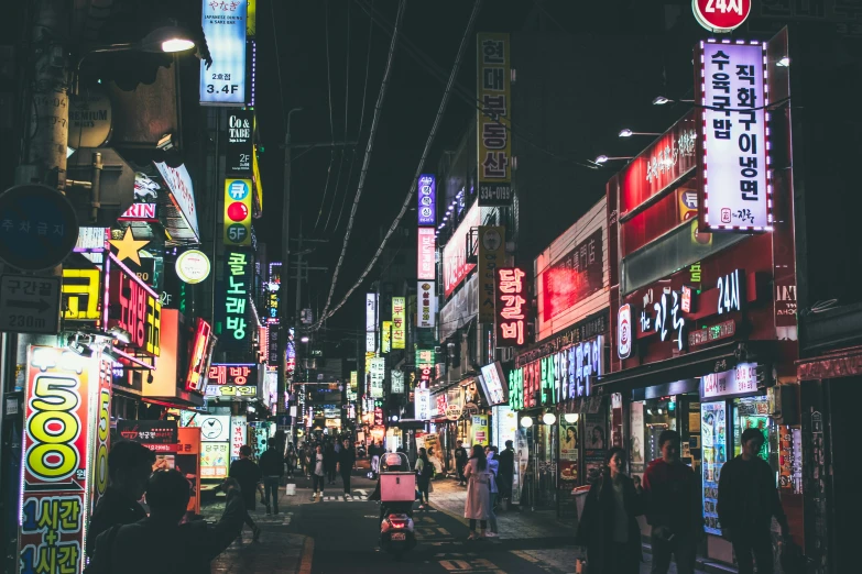 a city street is lined with brightly lit signs