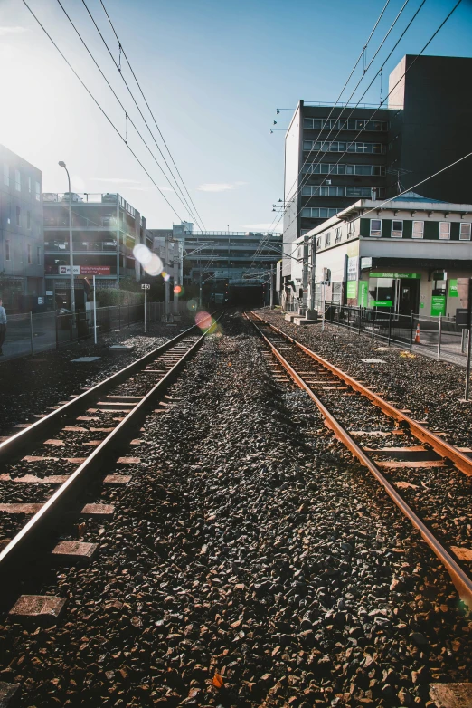 the train tracks pass by a building in an empty city