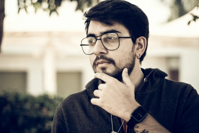 a man wearing glasses is thinking and posing for a po