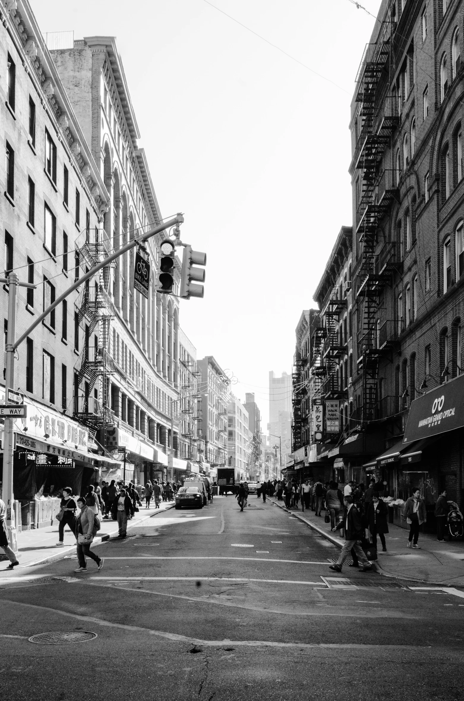 a group of people walk across a street in front of buildings