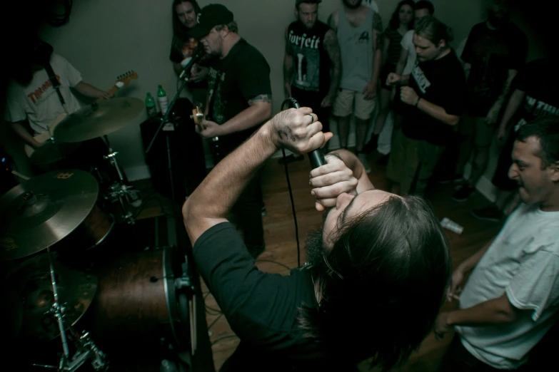 a crowd of people standing around a man holding a microphone