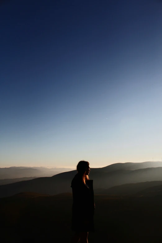 woman in a black dress looking up into the sky