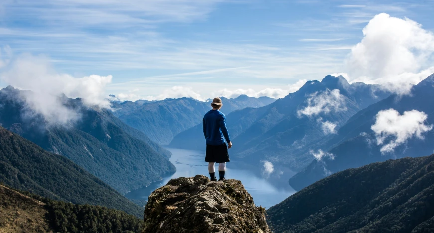 a person standing on top of a rock looking over mountains