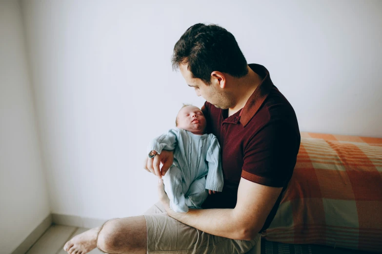 a man holding a baby sitting on a couch